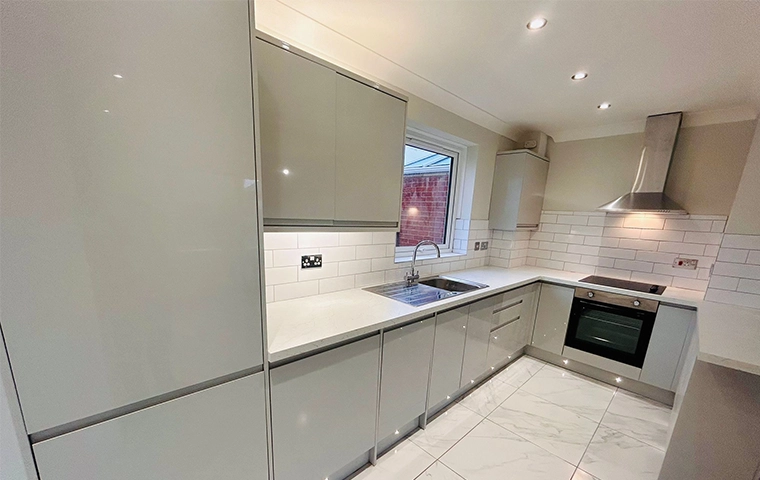 Modern handleless kitchen with push-to-open units and quartz surfaces